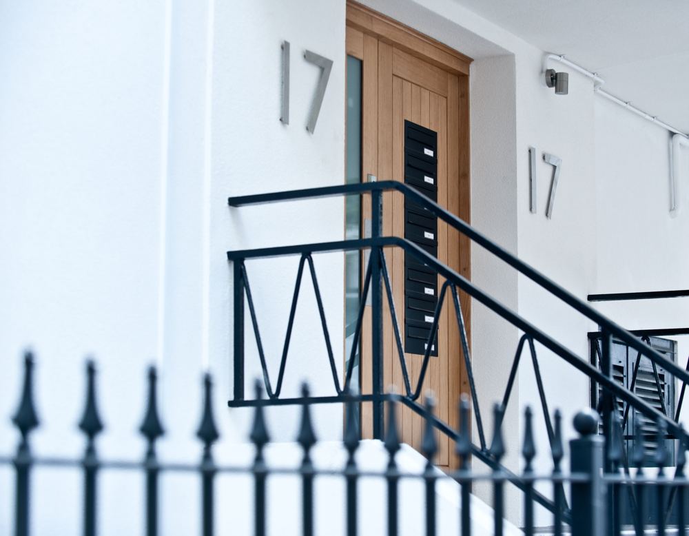 Oak front door with house number and black railings
