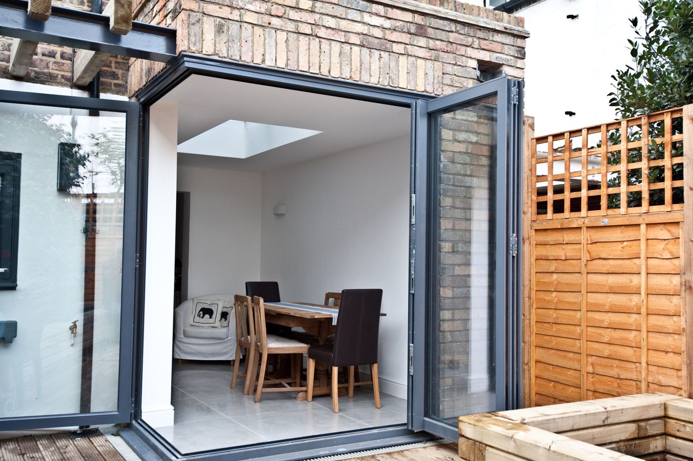 Brick rear extension with open bi-fold doors onto a deck