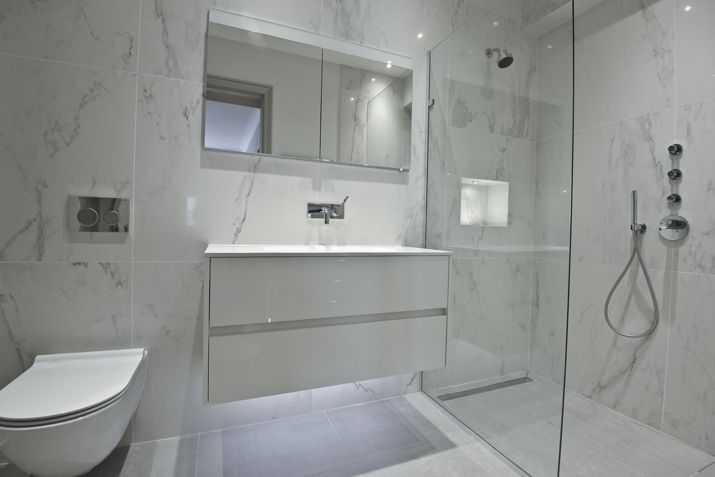 Marble-tiled shower room with wall-hung WC