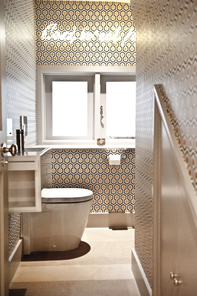 Cloakroom with patterned wallpaper and illuminated sign