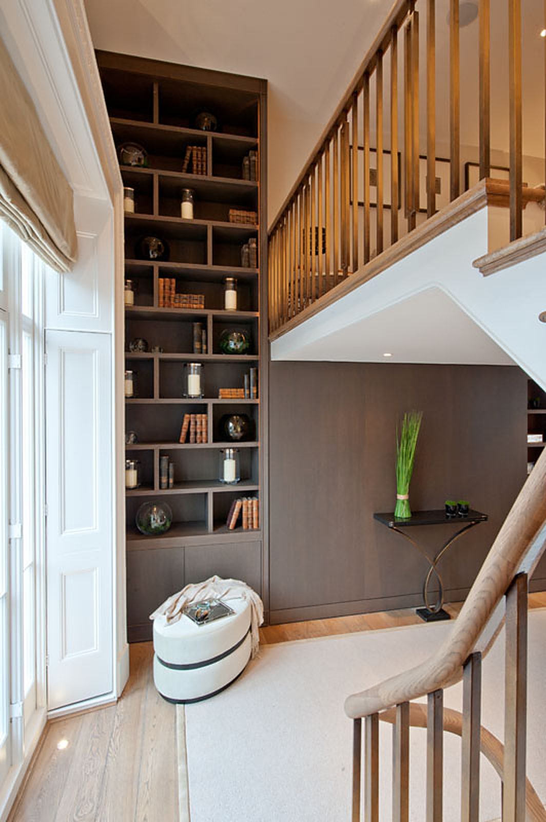 Double-height stair hall with full-height oak bookcase and panelled wall