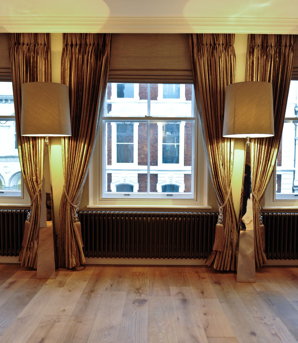 Drawing room with tall sash window, curtains and oak floor